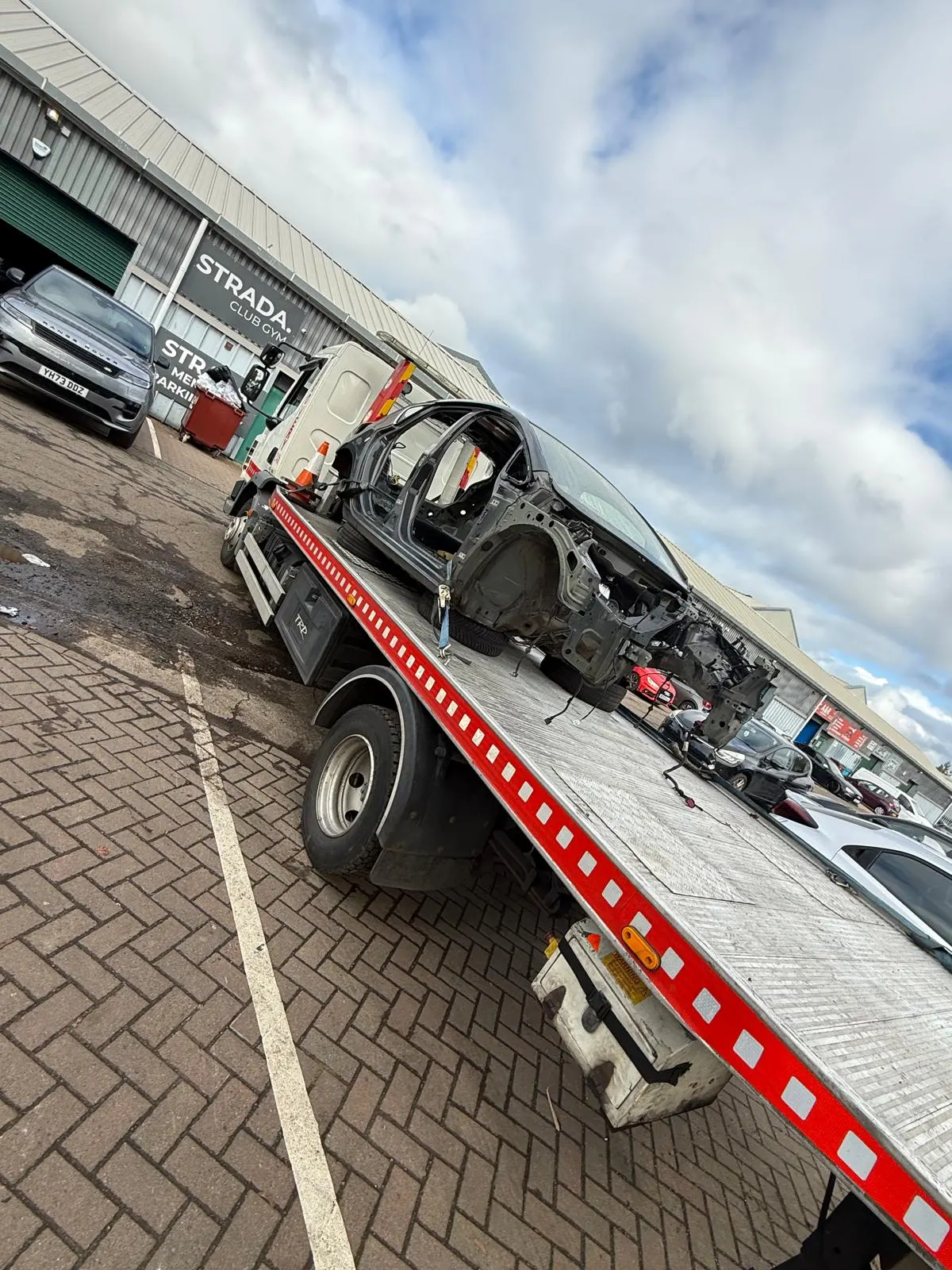 Stripped end-of-life vehicle on recovery truck