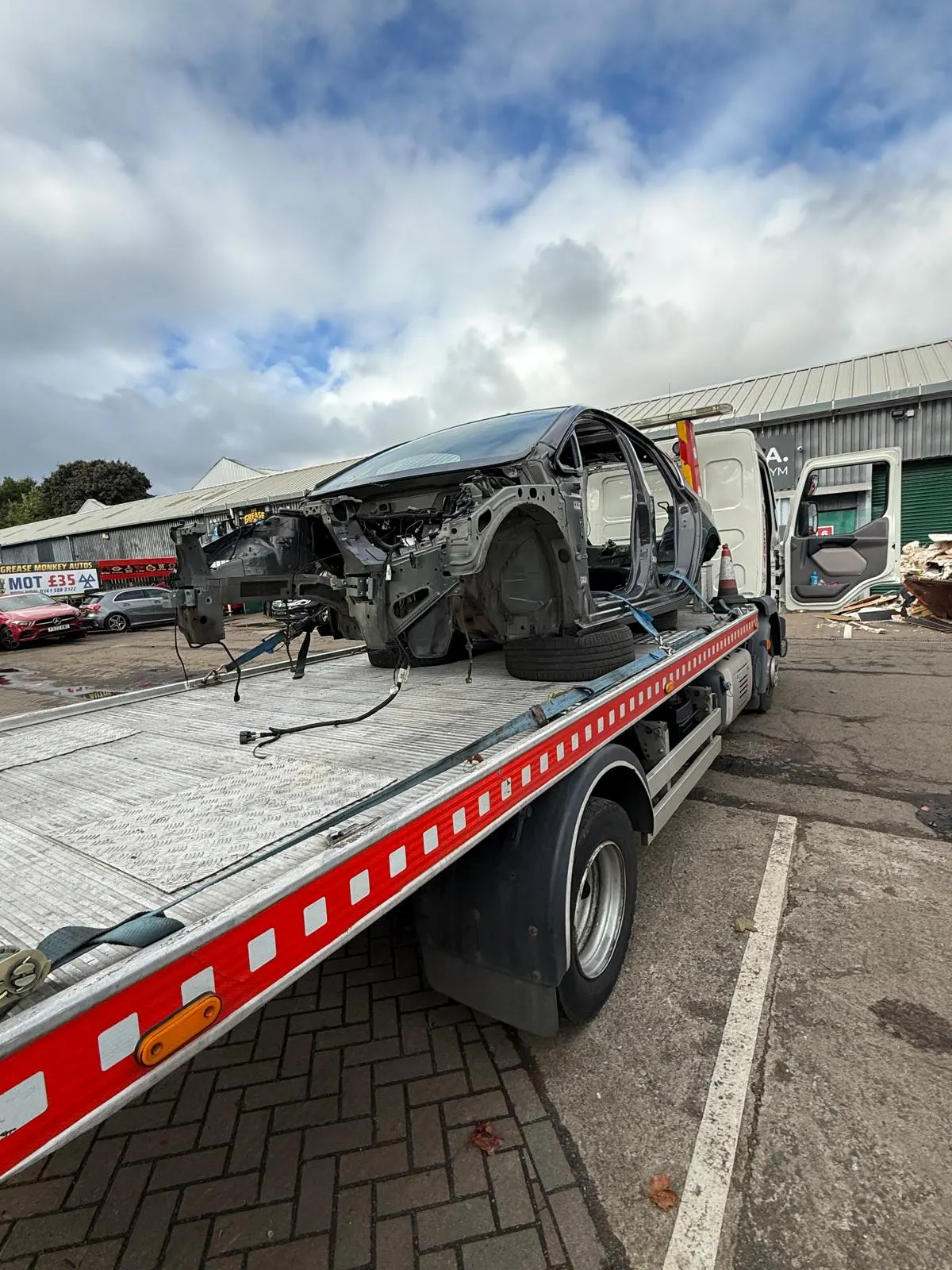 Damaged stripped vehicle shell on recovery truck